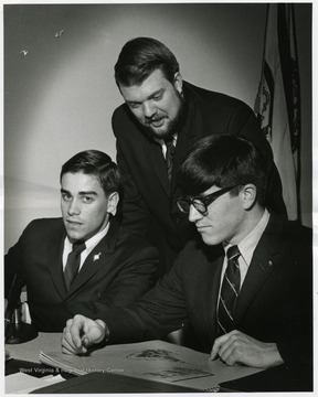 'The British and American Colonists have been at it again -- arguing and making history.  West Virginia University Director of Debate William Barnett (center) and student debaters John Straub (left) and Lewis G. Brewer are shown above bidding farewell to their Bristol (England) University opponents at the conclusion of the world's first trans-Atlantic telephone debate.  The hour-long experimental debate, an idea which originated with Barnett, was held Tuesday (March 12) afternoon and, although the contest wasn't judged, the issue stirred considerable enthusiasm and trans-Atlantic laughter.  The idea for the debate may have been conceived by the West Virginians but the Bristol students get full credit for "Resolved: That Christopher Columbus and Ford Motor Company Should Have Stayed at Home."