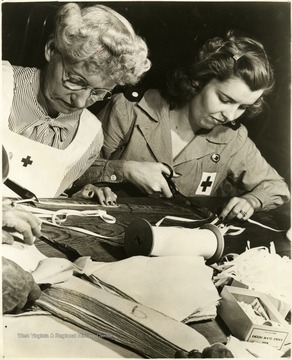 'Washington D. C., May, 1946. Volunteering their services this summer, these volunteers at the District of Columbia Red Cross Chapter, Washington D. C., are making Layettes as their part in the program to help clothe needy war-victims. Left to right, Mrs. Vernon Boggs and Mrs. James Loomis.'