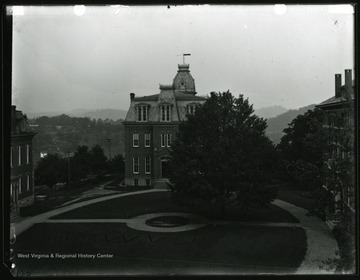 A view of Woodburn Circle: Martin Hall on left, Woodburn Circle on center and Chitwood Hall on right.  There is an lawn work reading WVU in the center of the circle.