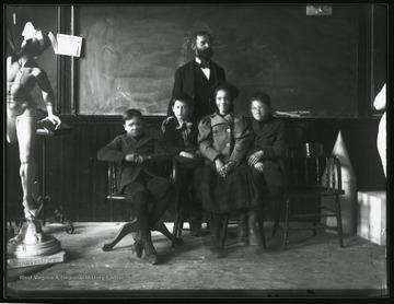 A student, Elmer Leach, Elmer shown here with four kids in a classroom in Science or Chitwood Hall.