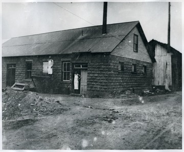 A view of old dairy with a few dairy workers near the building.
