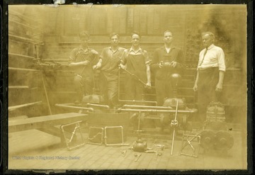 Students of pipe fitting class of 1927 pose in Mechanical Hall with Rufus West on far right.