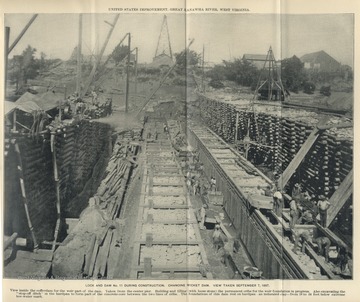 'View inside the cofferdam for the weir part of the dam. Taken from the center pier. Building and filling  (with loose stone) the permanent cribs for the weir foundation in progress. Also excavating the 'stop-off ditch' in the hardpan to form part of the concrete core between the two lines of cribs. The foundations of this dam rest on hardpan - an indurated clay - from 18 to 24 feet below extreme low-water mark.'