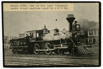 'One of the last diamond smoke stack engines used by C. &amp; O. Ry. out of Huntington about 1886. Ast Nagle Sr, engineer. Mrs. T. J. Bullock has the original of this. Says it was taken circa 1875 when her husband was a hostler on the C&amp;O,  The man at the throttle is T. J. Bullock and the foreman is ___ Bill.'