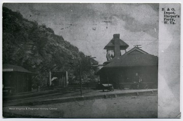 B. &amp; O. Harper's Ferry Depot: shown here are buildings on each side of rail roads and a locomotive is coming into depot crossing a steel span bridge.