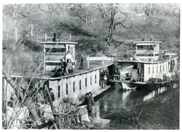'First Boat - 'Clarence' owned by Capt. C.C. Starcher (with paper in hand) on top: his wife, daughter, and son - J.C. Starcher. Second Boat - 'Edith H' owned y Jim Huffman'.