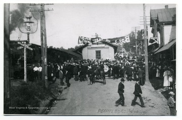 A railroad depot at Pennsboro, W. Va.: a crowd and a band gather at the station welcoming somebody on board arriving at the station. 