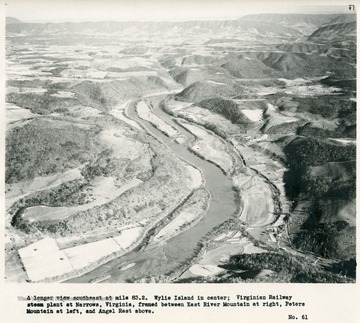 'A longer view southeast at mile 83.2.  Wylie Island in center; Virginian Railway steam plant at Narrows, Virginia, framed between East River Mountain at right, Peters Mountain at left, and Angel Rest above.'