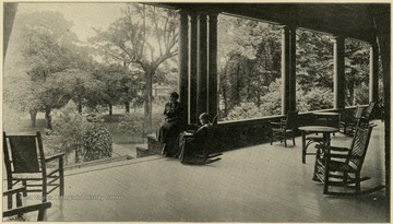 Two girls sit of the porch of dormitory Veranda.