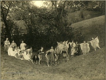 Student performers in togas and classical costumes. Taken on school property. Herscel D. Wade is in the foreground with black shawl over head.