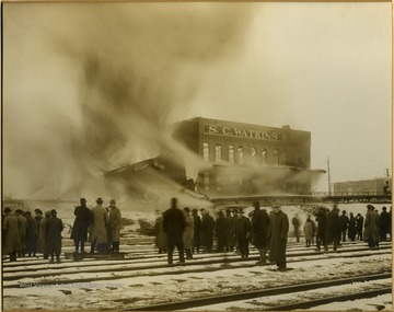 People stand on the tracks in front of S. C. Watkins Warehouse to see the fire.