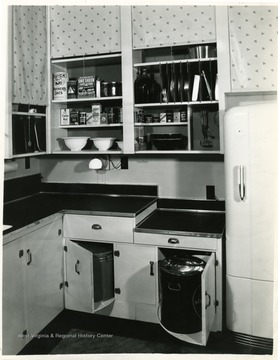 A display of hidden utility cans in cabinets in a model kitchen.