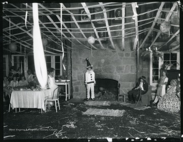 A scene from a party held at Jackson's Mill, participants are dressed for the occasion, child in center dressed as a clown. 