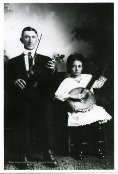 Ira D. Cox with violin and his daughter Lucille Cox with banjo.