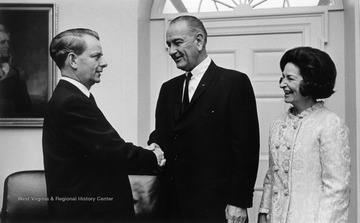 Robert C. Byrd shakes hands with President Johnson while First Lady watches over. 'Original moved with R.C.B. Collection to the R.C. Byrd Center for Legislative Studies at Shepherd University.'
