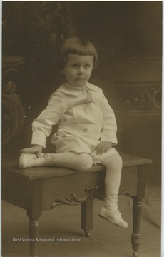 Portrait of a child sitting on a wooden bench.