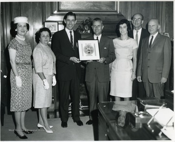 Gov. W.W. Barron holding Conservation plaque. From left to right: Warren Lane, director of Dept. of Natural Resources holding other end of plaque, and C.K. Dorsey on far right. 