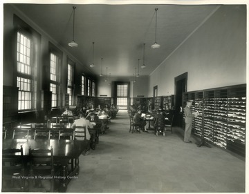 Students study at tables and peruse periodicals on the shelves in the General Reading Room.