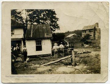 A group of men working on a home. 'Jesse Ellison house in background.'