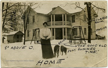 A descriptive picture of Clara Measimore standing in front of the house of her father, J. Z. Ellison. 