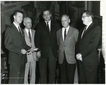 Harry Heflin (far left) and President Paul Miller (second from right) standing with other individuals in White Hall.