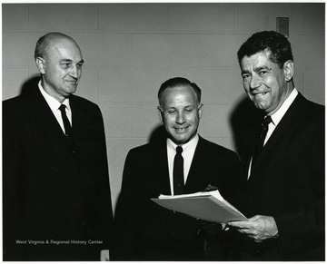 A photograph of Dean Nesius (far left) standing with two other men.