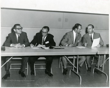 A picture of James Kent (second from right) and C.A. Arents (third from right) seated with two other men.