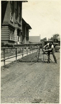 A photograph of a man testing a piece of mining equipment outside a building.