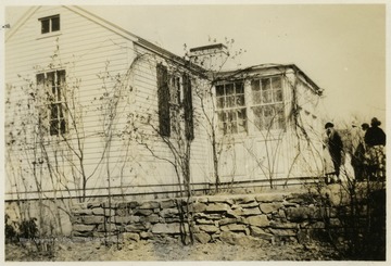 A photograph of what appears to be a home with people gathered in front.