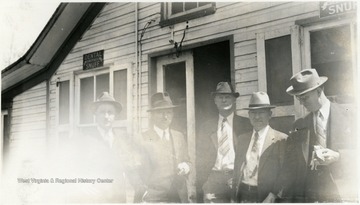 Undated photograph of unidentified group of men in front of a general store