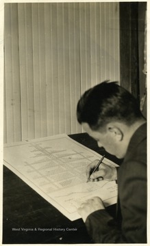 A photograph of a student working on a drawing of a ventilation system.