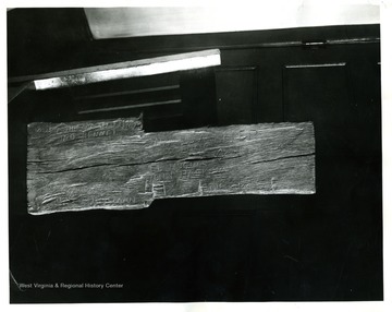 'Section of log taken from cabin built in the present city of Clarksburg, near the southeast corner of the Main St. at the intersection of East Main St. &amp; Monticello Ave. bridge over Elk Creek.  The original size of the cabin was 18 feet x 20 feet.  Building was demolished May 1933 in preparing for construction of a filling station.  Following names and items are carved into surface of log: WM Lowther; Jess Hughes; El Hughes; J. Ratcliffe; Jon Merrick; Jake Eib; Soth Hickman; John Hacker; Cole B. Rowen; J.G. Jackson; Masonic Emblem--killed this day Sept. 3, 1787; Jno Bennet (Bonnet).  The original section of log is now preserved in the Public Library at Clarksburg, West Virginia.'