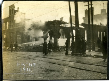 Aftermath of the Fire of 1911, fire crews are still hosing down the ruin. 