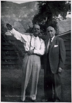 A photograph of two unidentified men standing outside.
