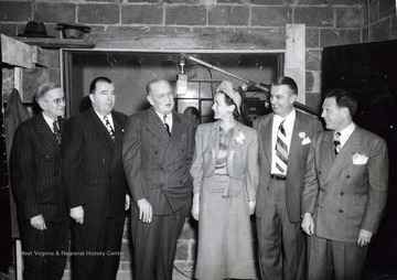 A photograph of Jennings Randolph (second from left) standing with Robert Lee McCoy (left), C. "Ned" Smith (third from left), Mrs. J. P. Beacom (third from right), Mr. J. P. Beacom (second from right), and Mr. Charles Grossman (right).