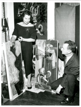 Grace Martin Taylor and a male with possibly her paintings. 