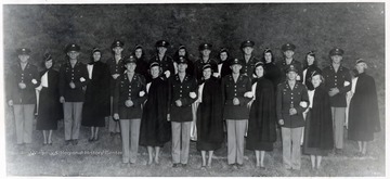 'From left to right, front row: Cadet Lt. Colonel Paul W. Cole, Commander, Second Battalion; Miss Carol Dean, Logan, West Virginia; Cadet Colonel Alfred Ware, Commander, Cadet Regiment; Miss Dolores Jamison, Morgantown, West Virginia; Cadet Lt. Colonel William Aldrich, Commander, First Battalion; Miss Natalie Brooks, Morgantown; Cadet Captain James E. Price, Band Captain; Miss Marian Caso, Charleston, W. Va.; Back row: Cadet Captain Donald Siegrist, Commander, Co. A, 1st Bn.; Miss Mary Alice McLaughlin, Weston, W. Va.; Cadet Captain Doyle Smith, Commander, Co. B, 1st Bn.; Miss Adelaide Thieroff, Wheeling, W. Va.; Cadet Captain Bulan Thomas, Commander, Co. C, 1st Bn.; Miss Peggy Brown, Princeton, W. Va.; Cadet Captain James Quinn, Commander, Co. H, 2nd Bn.; Miss Phyllis Walker, Charleston, W. Va.; Cadet Captain Frederick Shafferman, Commander Co. G, 2nd Bn.; Miss Barbara Lou Shouldis, St. Marys, W. Va.; Cadet Captain Clem Wiechman, Commander, Co. E. 2nd Bn.; Miss Susan Ball, Hinton, W. Va.; Cadet Captain Ray Friant, Commander, Co. F, 2nd Bn.; Miss Nancy Cook, Charleston, W. Va.; Cadet Captain Richard Davis, Commander Co. D, 1st Bn.; Miss Barbara Shumaker, Morgantown, W. Va.'