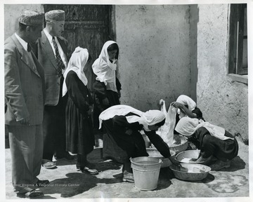 'Left to right Mr. Samimi of the Afghan Rural Development commission and Mr. Robert M. Snyder Director USOM/Afghanistan watch girls in the village school in the Logar Valley. The girls are learning proper methods of cleanliness.'