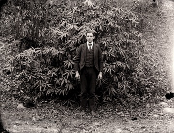 A portrait of young man taken in front of rhododendron tree in Helvetia, W. Va.