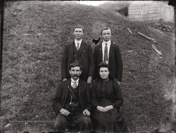 A portrait of a man and woman and two young men.