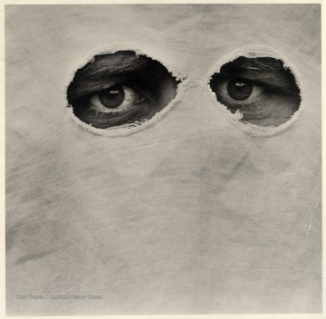 Close up of the eyes of a Ku Klux Klan Member.