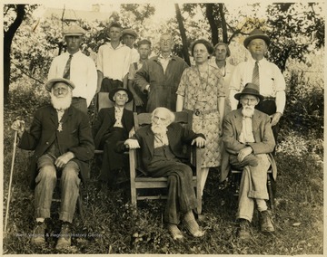 Front row, left to right:  Abraham Nuce (age 81), George Nuce (seated, age 92), Michael Nuce (seated, age 78).  &#13;Middle row, left to right: Michael R Nuce (cap and tie, age 58), Henry Nuce (seated, age 84), Virginia Belle "Jennie B" Nuce (patterned dress, age 46), Horace Flenniken (age 50).  &#13;Back row, left to right: Virgel Blosser (age 18), Omer Halbert (age 15), Orrie Roahr (age 11), George Snyder (coveralls, age 55), Anna Nuce. The three boys and George were boarders in the Nuce household.&#13; Abraham and George were Civil War veterans serving the Northern cause in the U. S. Army.  Identifying information in A&M 3021 Nuce Family Collection.