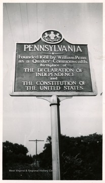 A Pennsylvania highway marker stands between Wheeling, W. Va. and Washington, PA on the US Route 40.  The marker reads: Pennsylvania--founded 1681 by William Penn ans a Quaker Commonwealth, Birthplace of the Declaration of Independence and the Constitution of the United States.