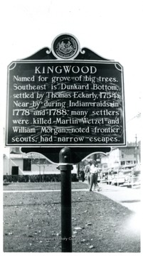 The historic marker reads: Kingwood--Named for grove of big trees.  Southeast is Dunkard Bottom settled by Thomas Eckarly 1754.  Near by during Indian raids in 1778 and 1788.  Many settlers were killed Martin Wetzel and William Morgan, noted frontier scouts, had narrow escapes.