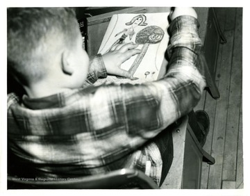 An unidentified school boy draws.