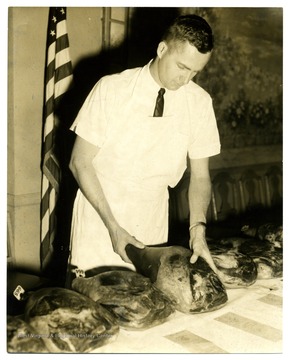 An unidentified man examines meat displayed.