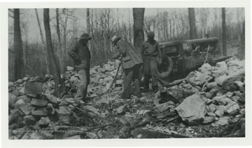 Three men surrounded by stone working. The names Jex and Bill appear on the back of photo.