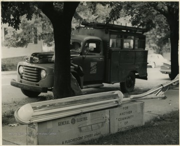 Installer is hidden behind a tree next to his utility truck.