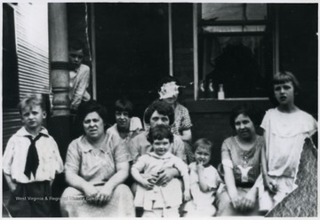 ' Far L- John (Jack) Nanz, Far R- Betty Nanz, Woman holding child: Mary H. Coleman Donahue, child Mary Dorothy Blume, child 3rd from R-Ruth Nanz,and woman with face scratched out Agnes Coleman Nanz.'