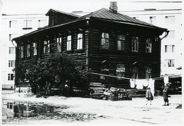 'Moscow--old and new house (multi-family) note the fire wood and new apartment house.'